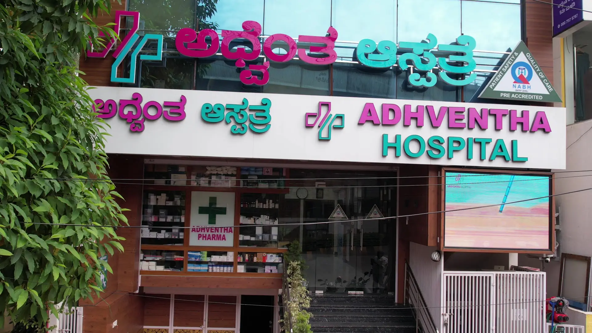 The entrance of Adhventha Hospital, with its signboard in Kannada and English